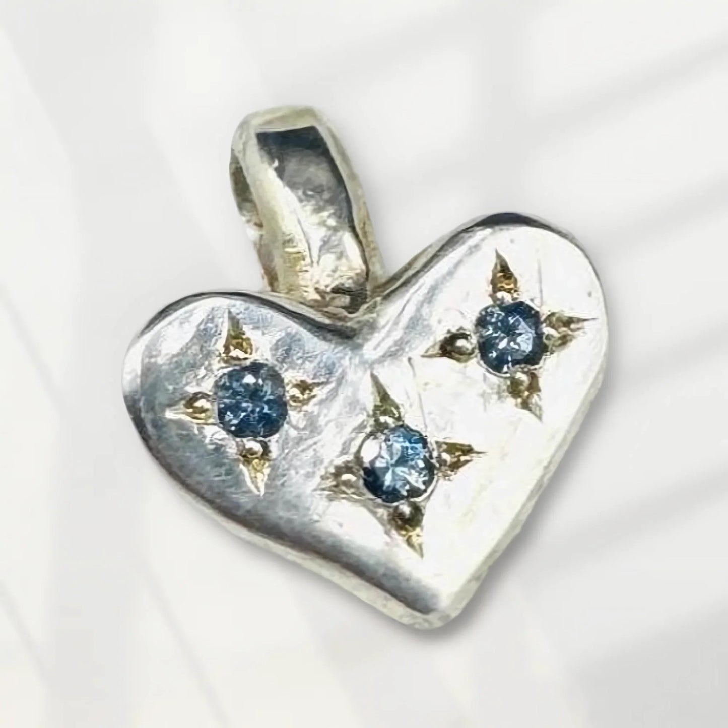 Handcrafted silver heart pendant with three blue gemstone accents, fine art jewelry