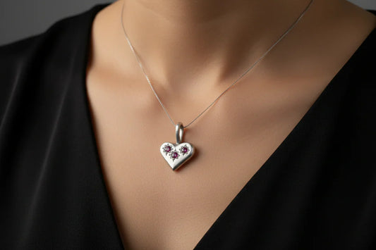 Handcrafted silver heart pendant necklace with floral design on woman in black top