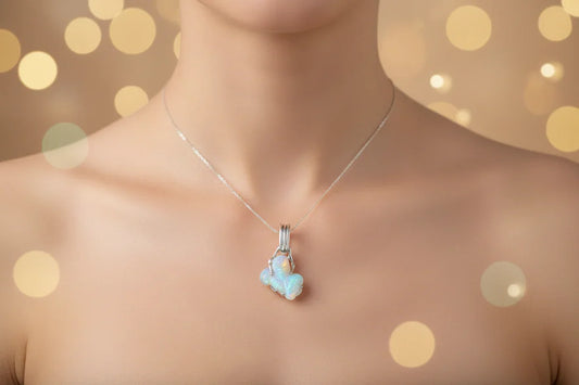 Handcrafted opal pendant necklace on silver chain, worn on bare neck, with bokeh background