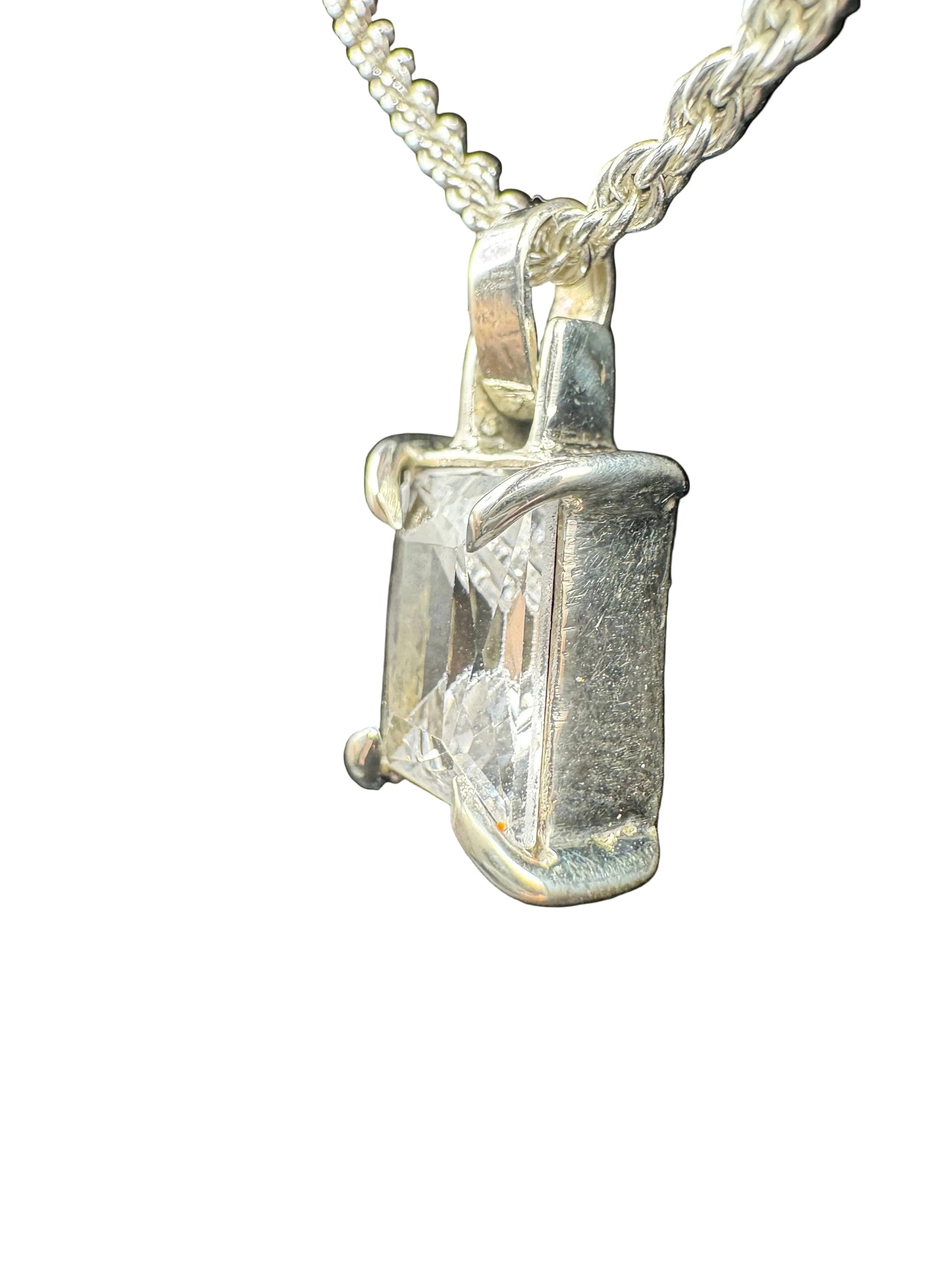 Diamond pendant on a chain against a black background