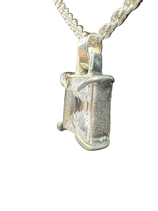 Diamond pendant on a chain against a black background