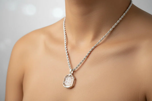 Handcrafted silver chain necklace with a clear gemstone pendant on a model's neck