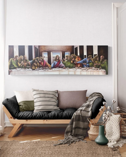 Living room with a black sofa, decorative pillows, and a painting of 'The Last Supper' on the wall.