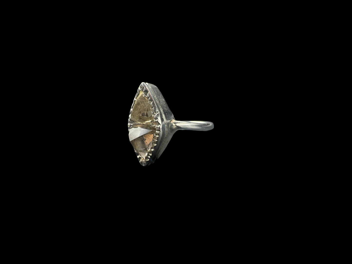 Decorative sunstone ring with small details engraved on a black background