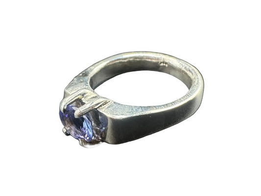 Silver ring with a purple gemstone on a black background