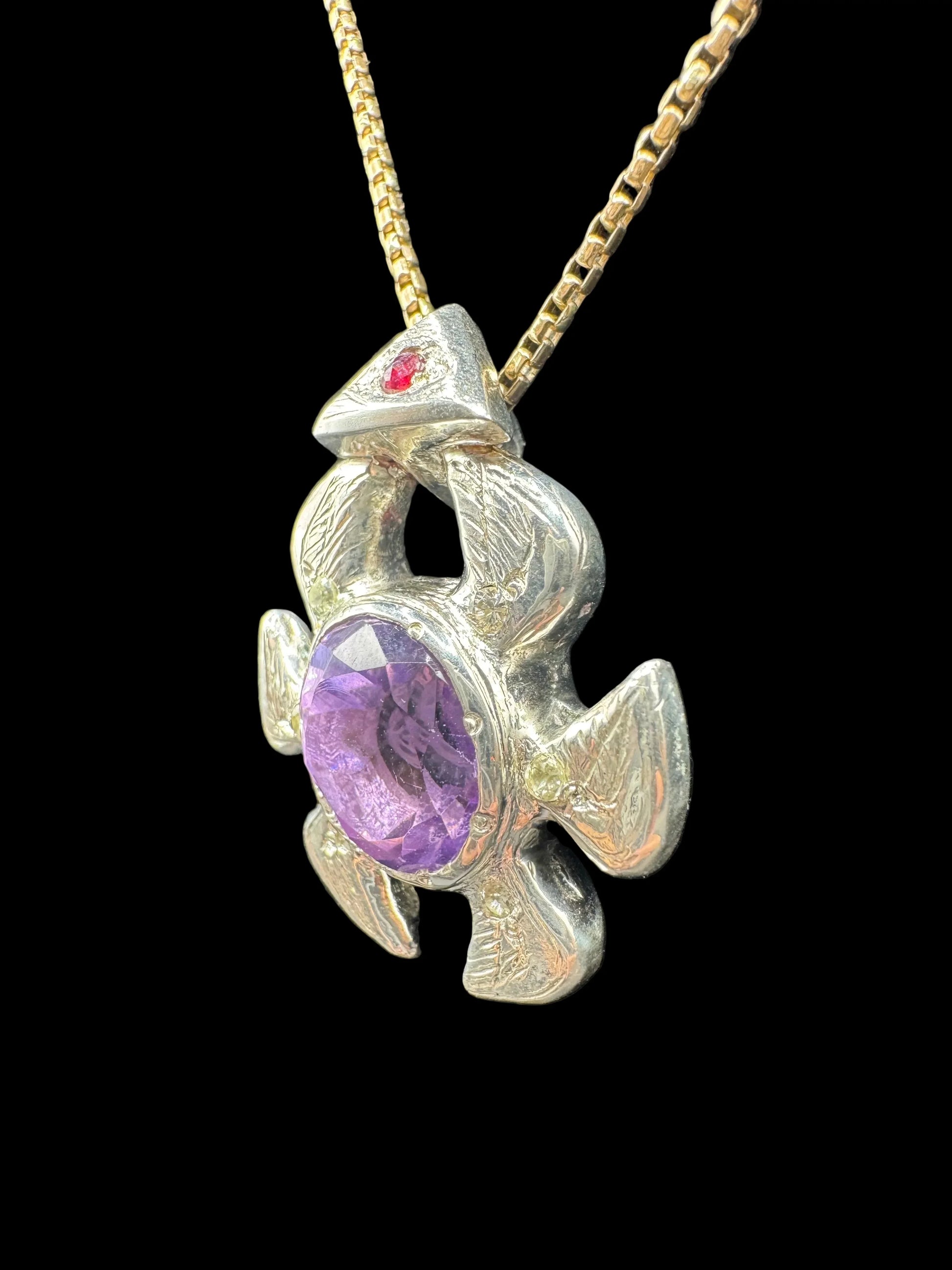 Handcrafted silver turtle pendant with purple gemstone and red accent on gold chain