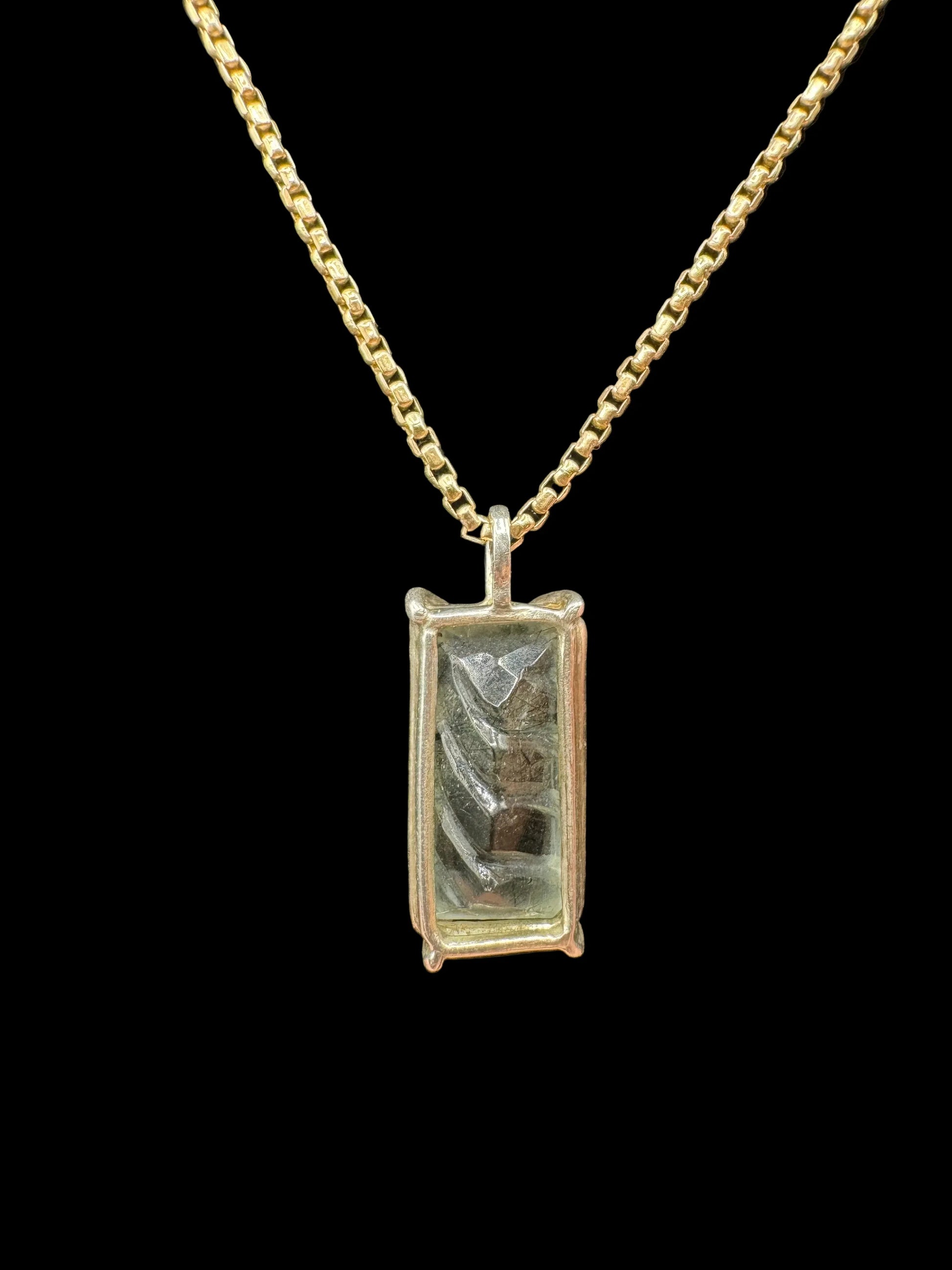 Rectangular handcrafted pendant with metallic pattern on a gold chain, fine art jewelry