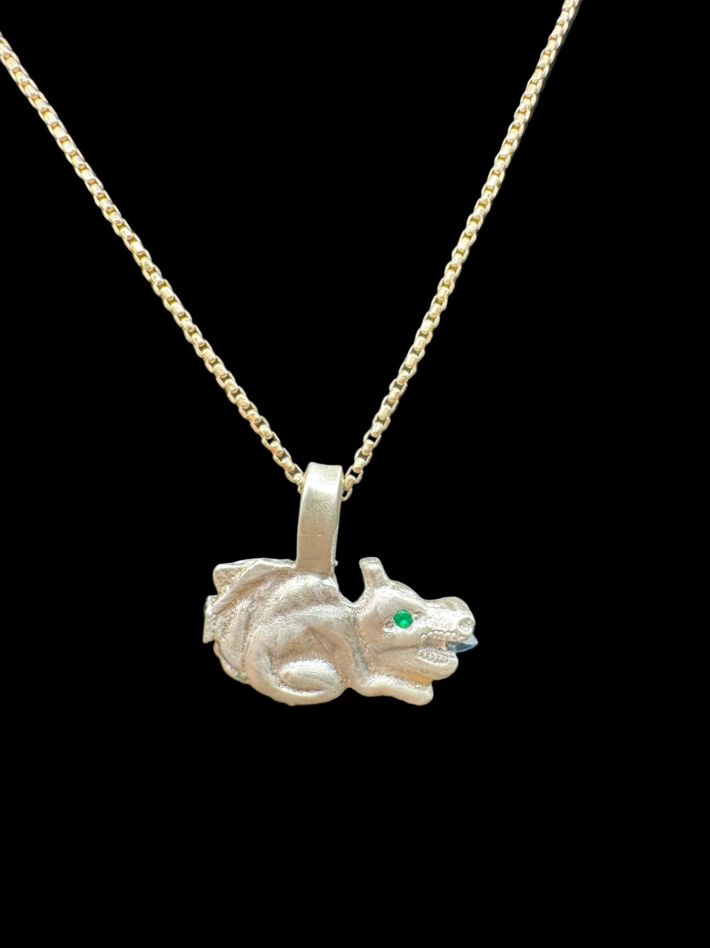 Handcrafted silver dragon pendant necklace with green gemstone eye on gold chain, black background