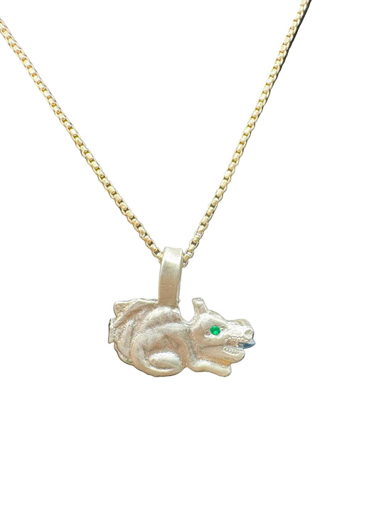 Handcrafted silver dragon pendant necklace with green gemstone eye on gold chain, black background