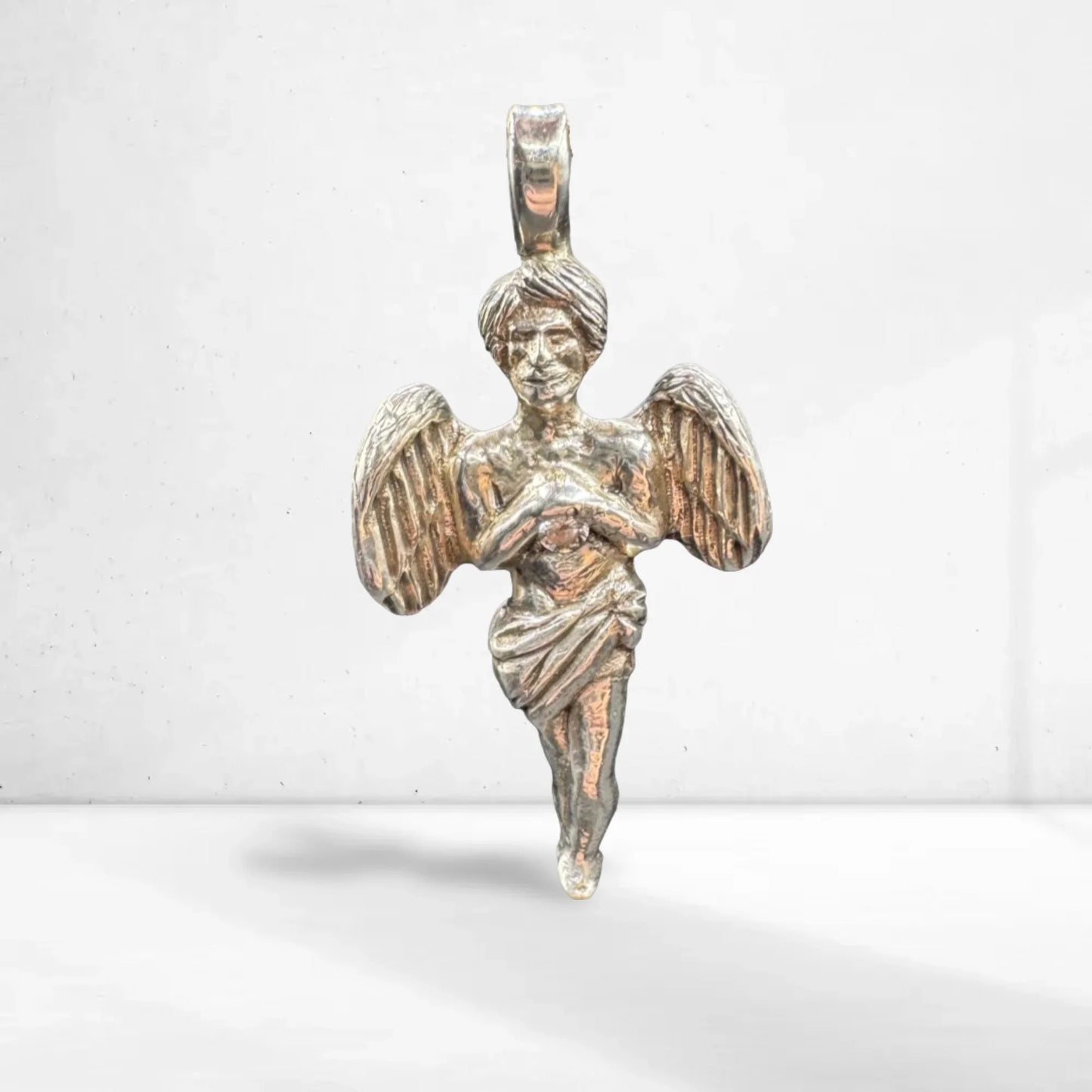 Handcrafted silver angel pendant with detailed wings and flowing robe on white background