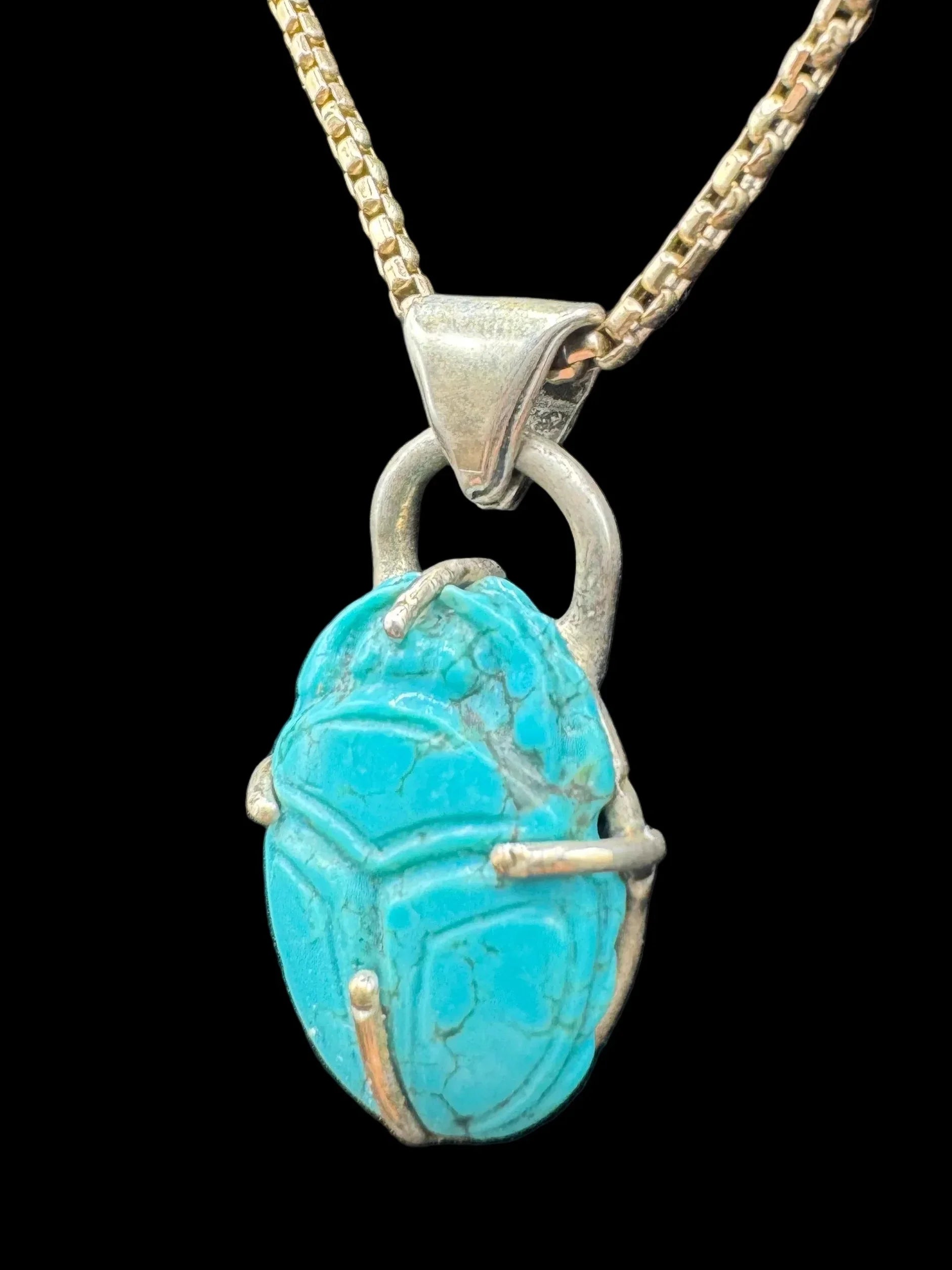 Turquoise scarab pendant on gold chain, handcrafted jewelry on black background