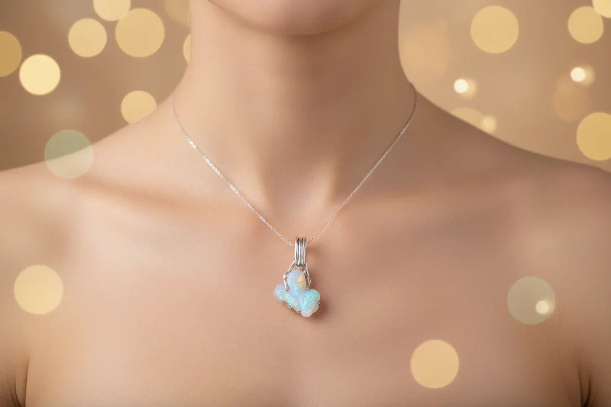 Handcrafted opal pendant necklace on silver chain, worn on bare neck, with bokeh background