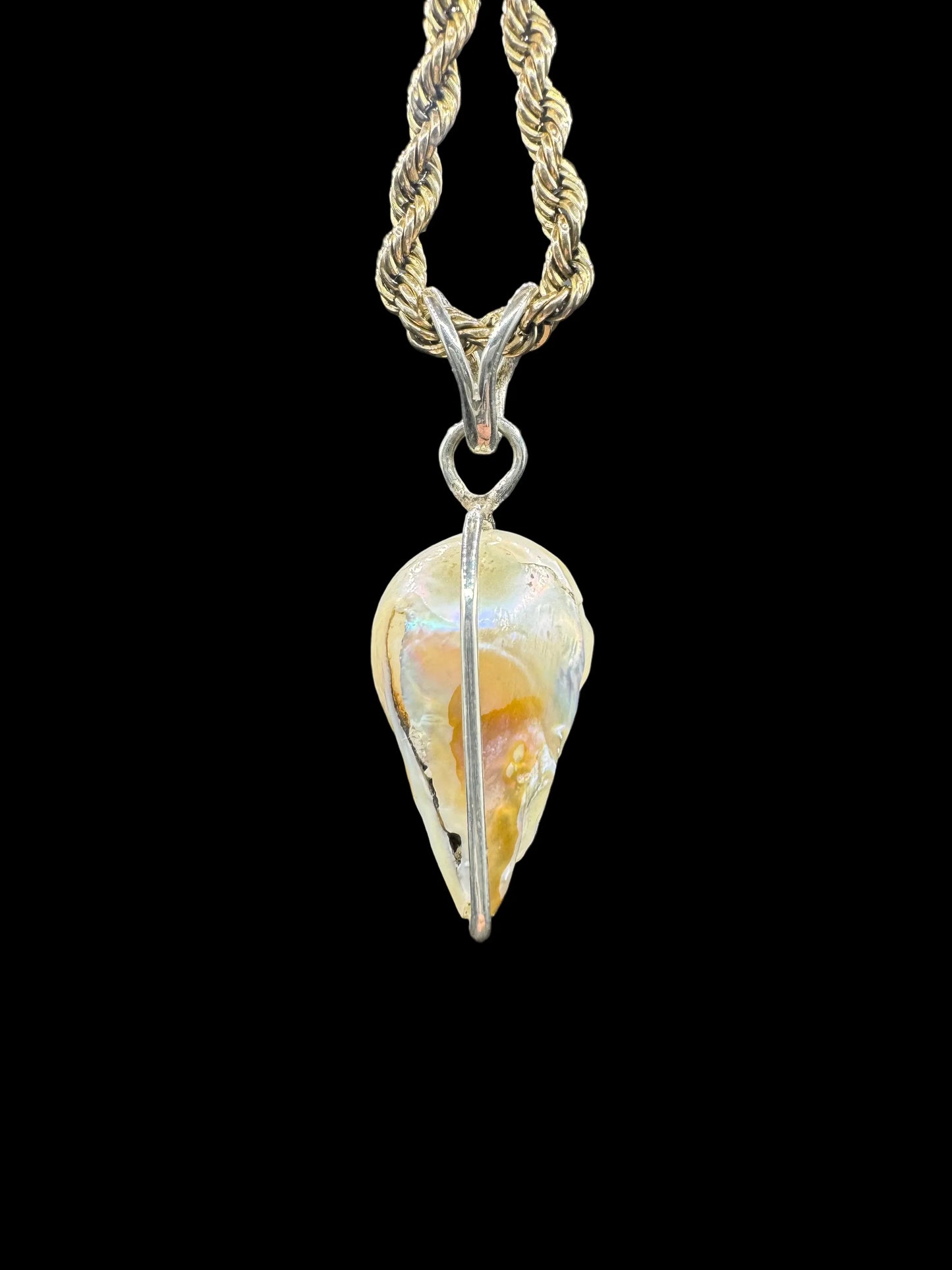 Handcrafted baroque pearl pendant with gold chain on black background, artisan jewelry