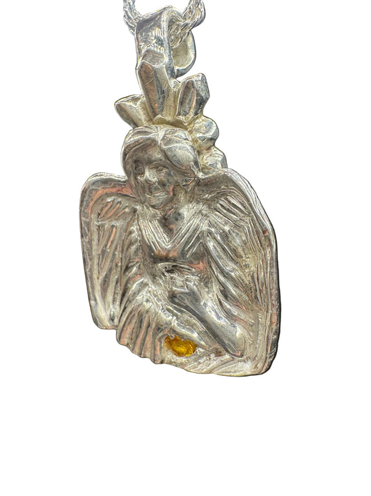 A silver-toned metal pendant or charm with a textured, organic leaf-like or wing-like shape, featuring a small amber-yellow inset detail, shown against a white background.