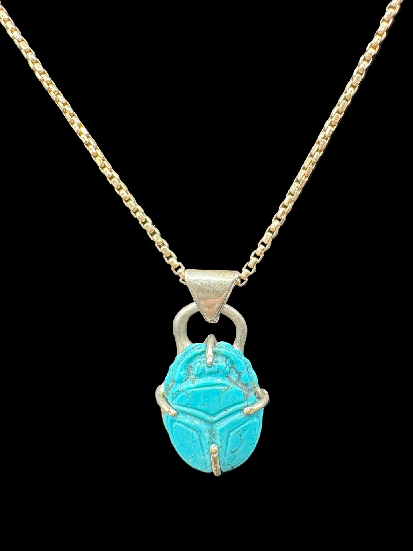 Turquoise scarab pendant necklace with silver chain on black background