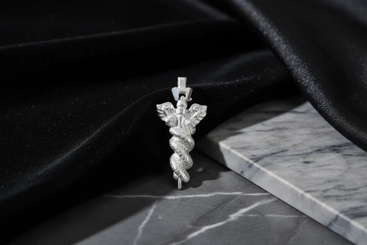 Sterling silver caduceus pendant on marble with black velvet, handcrafted jewelry photo
