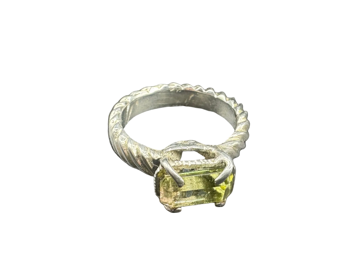 Silver ring with a green gemstone on a black background