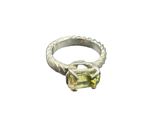 Silver ring with a green gemstone on a black background