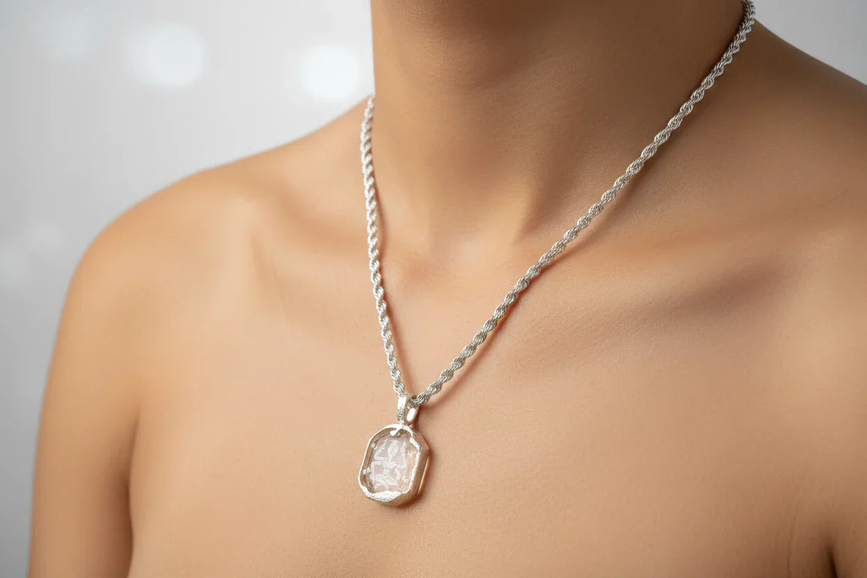Handcrafted silver chain necklace with a clear gemstone pendant on a model's neck