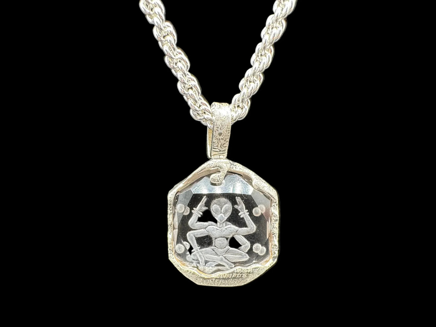 Handcrafted silver pendant necklace featuring an engraved meditating figure on clear crystal