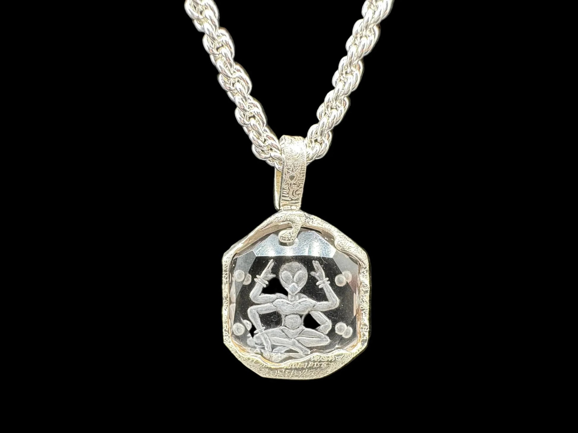 Handcrafted silver pendant necklace featuring an engraved meditating figure on clear crystal