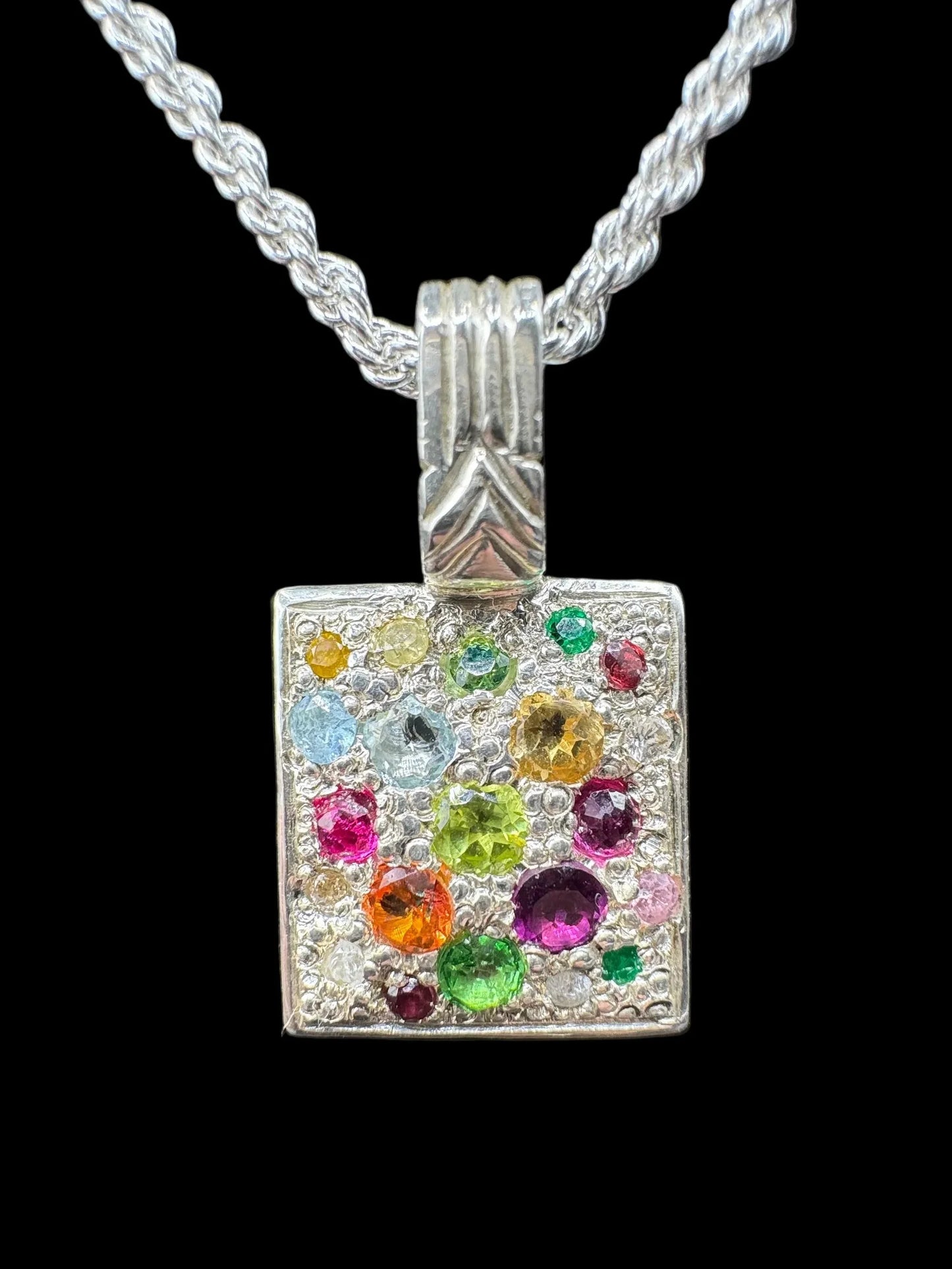 Square silver pendant with multicolored gemstones on a twisted chain necklace