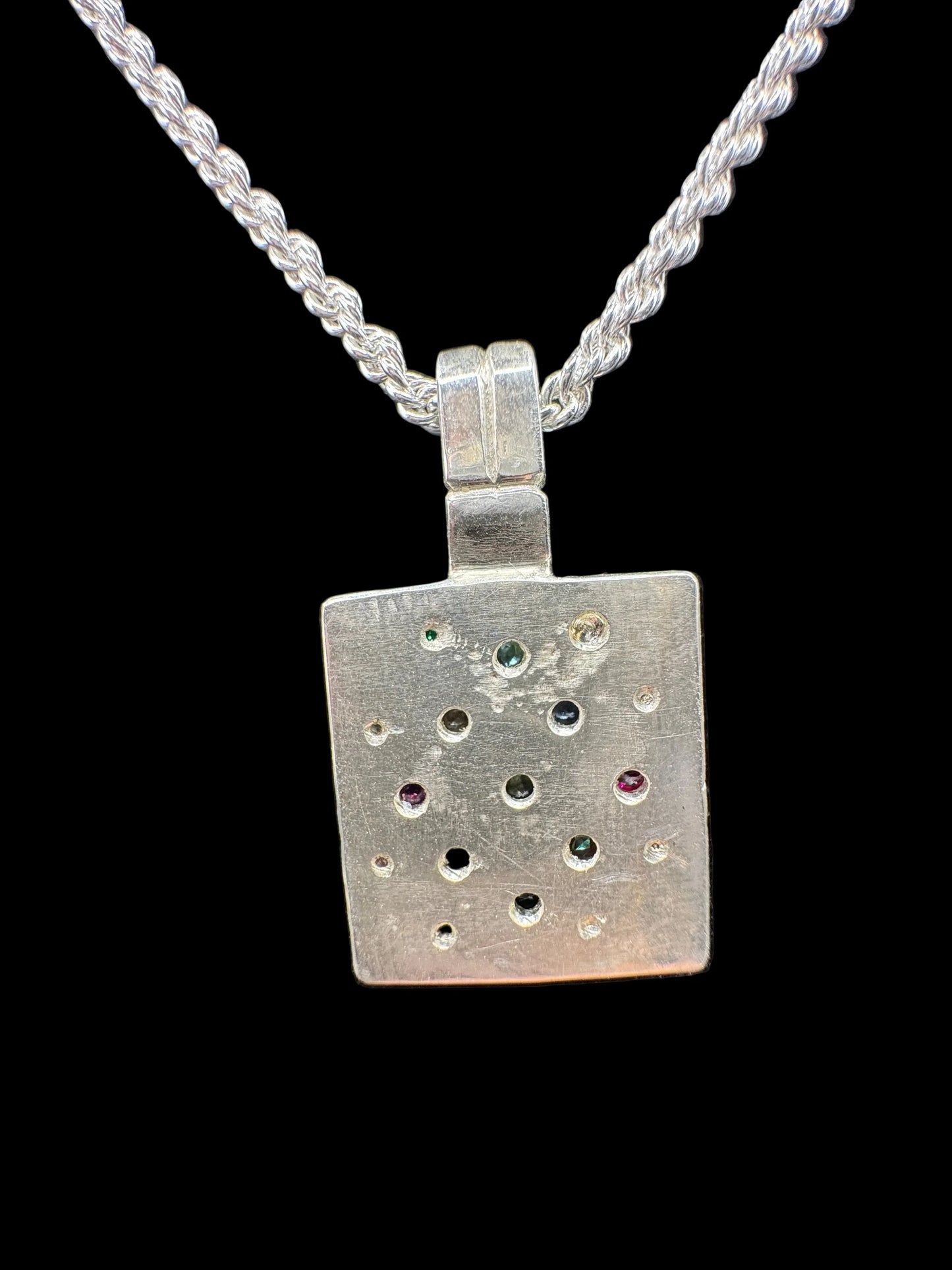 Handcrafted silver pendant necklace with multicolored gemstones on a twisted chain