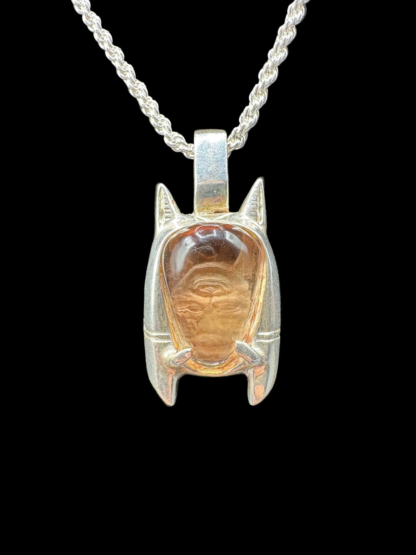 Handcrafted silver necklace with carved brown gemstone pendant featuring face design