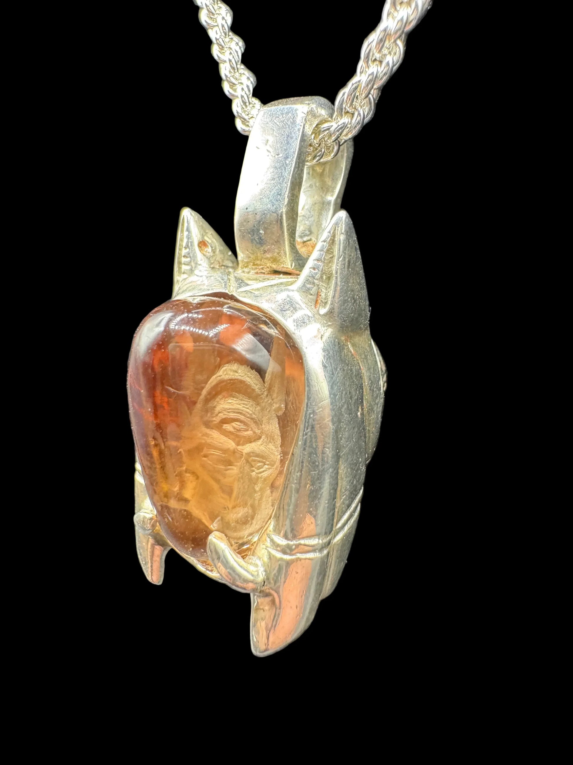 Silver handcrafted pendant with orange carved gemstone and intricate design on chain
