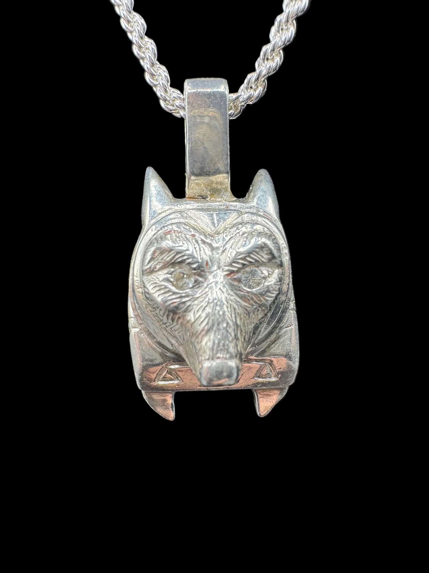 Handcrafted silver wolf head pendant necklace with detailed texture on black background