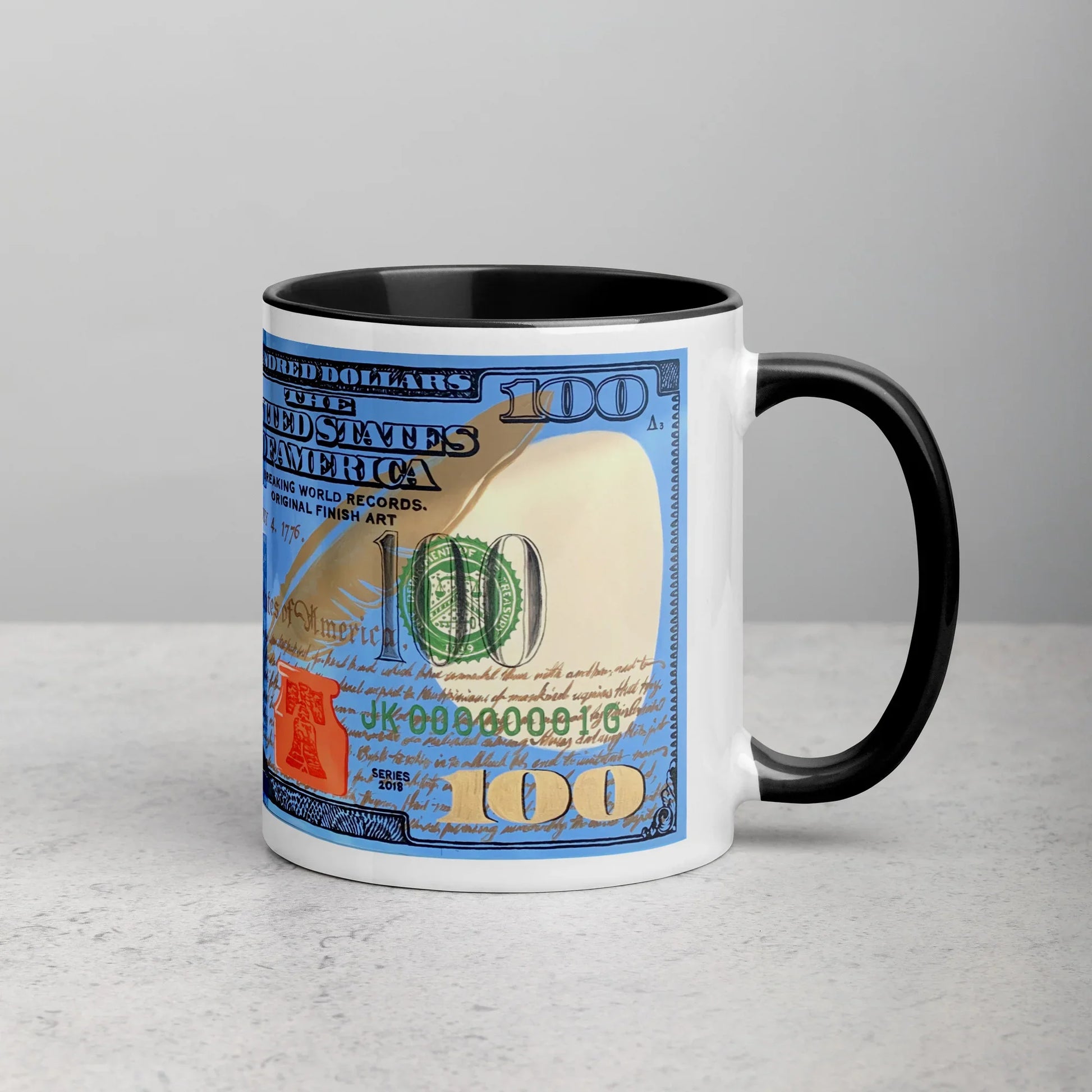 White ceramic mug with black handle and interior, featuring a colorful $100 bill design