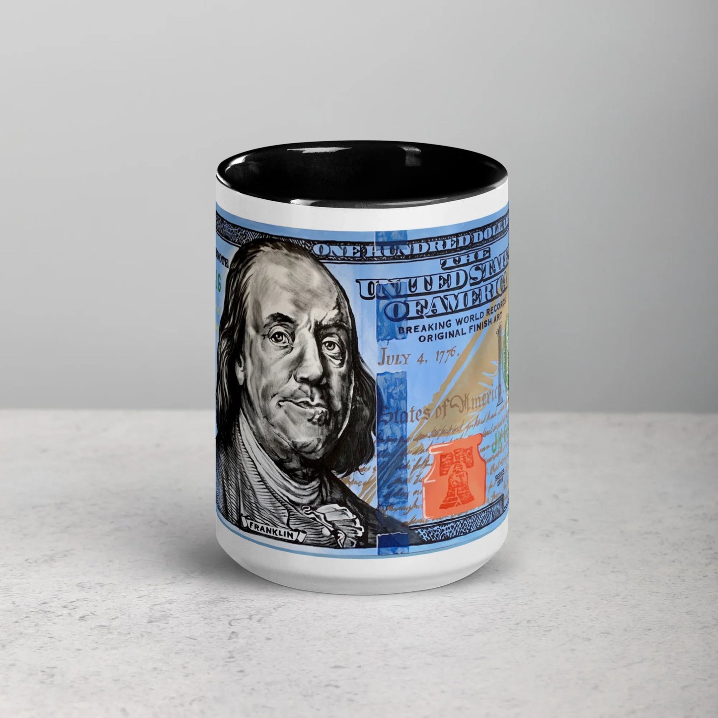 White ceramic mug with black interior featuring a blue hundred dollar bill design